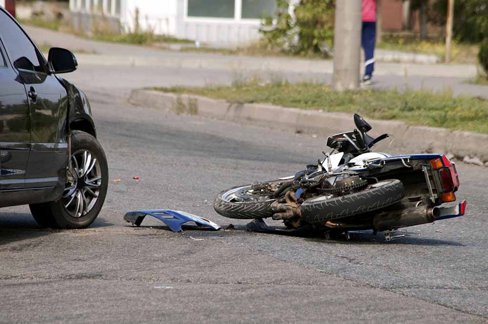 a-damaged-motorcycle-and-car-in-the-road-following-a-motorcycle-accident