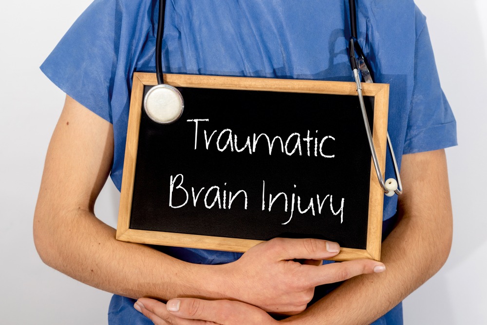 A nurse holds up a chalkboard that reads traumatic brain injury. El Dorado Hills injury attorneys can help.